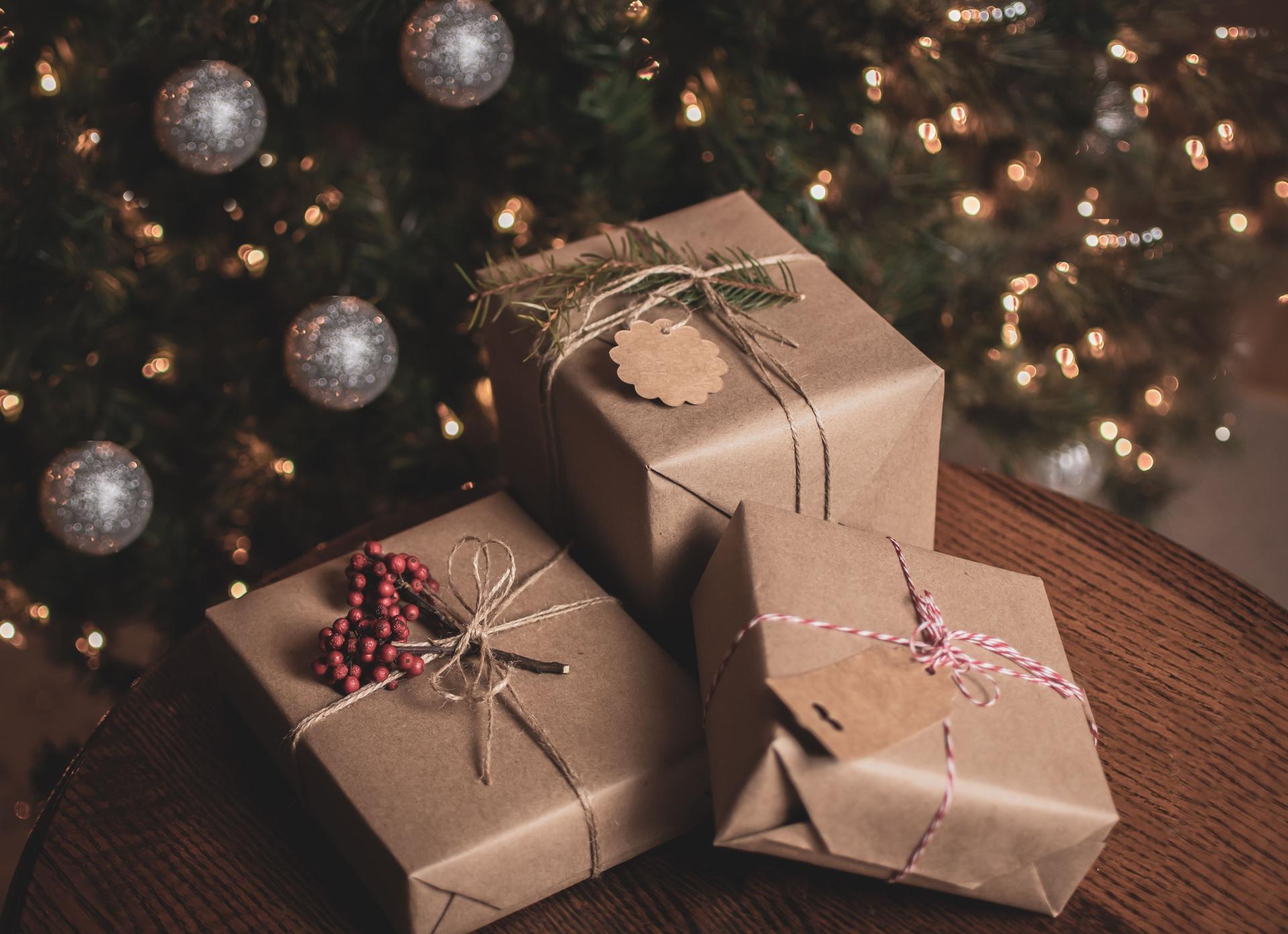 Christmas gift wrapped in brown craft paper on the table