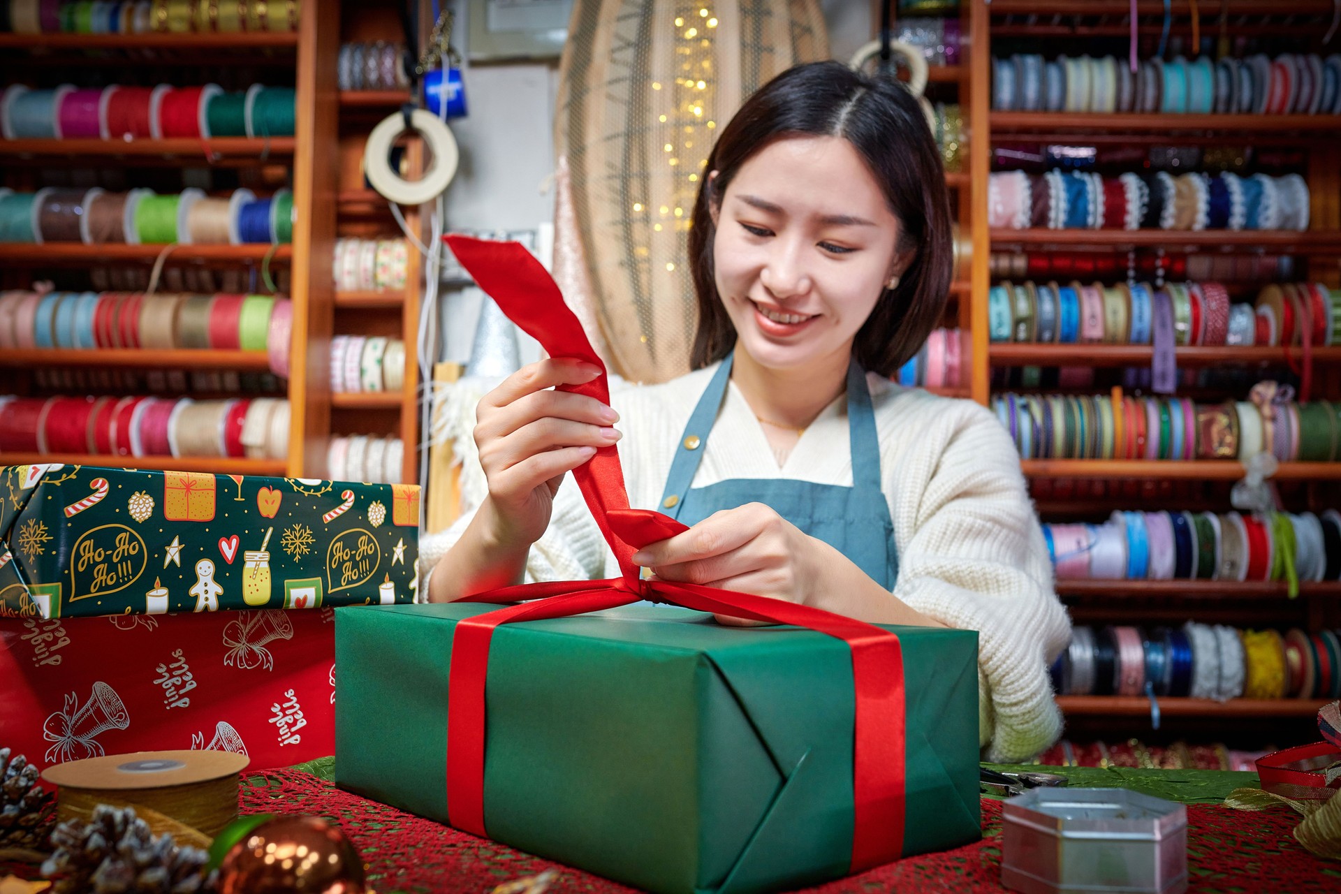 Front View of One Asia Female Craftsperson Wrapping Gift Box